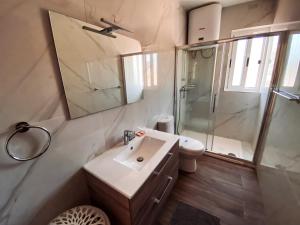 a bathroom with a sink and a shower and a toilet at Blue Sky Xlendi in Xlendi