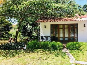 a small white house with a table in front of it at The Sattva Nature Retreat in Avathi