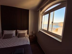 a bedroom with a bed and a large window at Blue Sky Xlendi in Xlendi