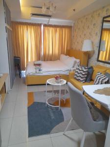Habitación con cama, mesa y sofá en Shell Residences by Amonbrey Suite nr airport en Manila