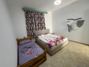 a bedroom with two beds and a window at Joen Apartment 3 in Sarandë