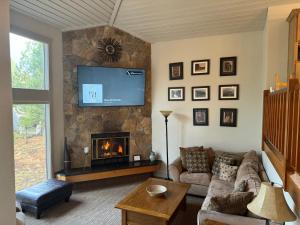 a living room with a couch and a fireplace at Great Kitchen, AC, SHARC Access, Hot Tub, Bring Pet! in Sunriver