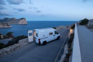 San FranceschBeautiful Campervan (Mallorca)的一辆白色露营车停在海边的路上 更多12张照片