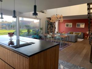 a kitchen and living room with a couch and a table at Maison spacieuse avec piscine au sel proche grand stade in Sainghin-en-Mélantois