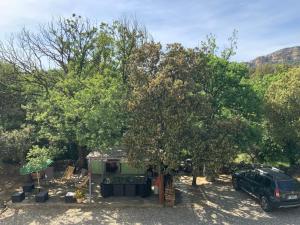 a car parked in front of a house under a tree at U FARNIENTE in Patrimonio