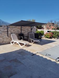 two white chairs and an umbrella on a patio at Le Domaine De Marie in Palasca