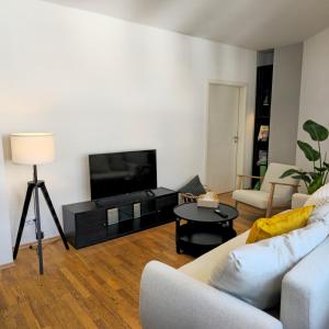 a living room with a couch and a flat screen tv at NORA One in Traben-Trarbach