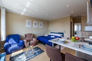 ein Schlafzimmer mit einem Bett, einem Tisch und Stühlen in der Unterkunft Apartments Sunset Centar in Rijeka