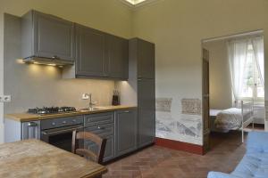 a kitchen with gray cabinets and a table in a room at Alloro 5 in Marciana Marina