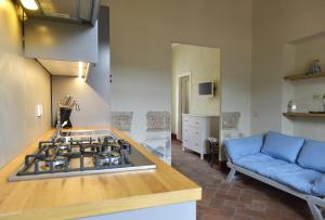 a kitchen with a stove and a blue couch at Alloro 5 in Marciana Marina