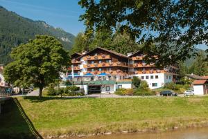 a house that has a boat in the water at Parkhotel Sonnenhof in Oberammergau