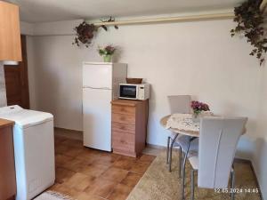 eine Küche mit einem kleinen Tisch und einer Mikrowelle in der Unterkunft Privát Stelly in Dolná Lehota