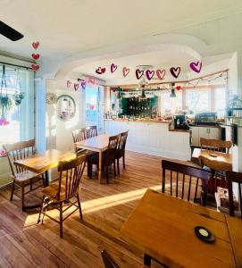 un restaurant avec des tables et des chaises en bois et une cuisine dans l'établissement Les Pinsons des Rives, à La Malbaie