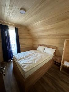 um quarto com uma cama grande num quarto de madeira em Bungyalow House - 5 Rooms em Zolaći
