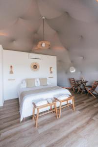 a bedroom with a large bed and a table at Glamping Puente Blanco in Sierra de la Ventana