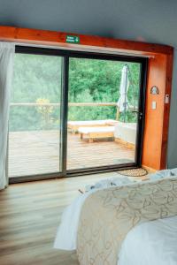a bedroom with a large window and a deck at Glamping Puente Blanco in Sierra de la Ventana
