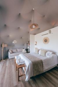 a bedroom with a large bed and a couch at Glamping Puente Blanco in Sierra de la Ventana