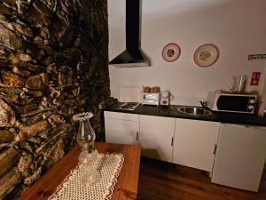 a kitchen with a counter and a stone wall at Segredo do Castelo do Sabugal in Sabugal +17 photos