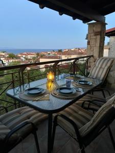 a table and chairs on a balcony with a view at Stone House in Afytos in Afitos