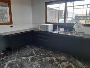 a kitchen with a counter with a microwave on it at Chacara com piscina e jacuzzi in Itu
