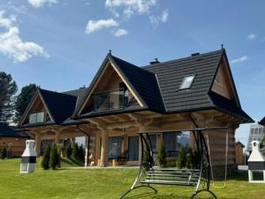 a house with a black roof on top of a house at Domki 4 Turnie in Ząb