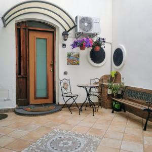 a room with a door and a table and a bench at Cortile di San Leo in Vietri sul Mare