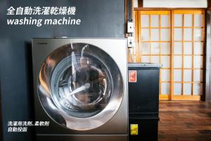 een wasmachine naast een muur bij 松本市の一棟貸し切りできる古民家 in Matsumoto