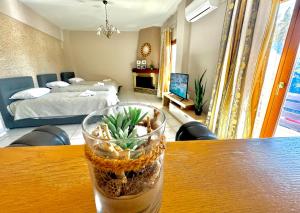 a glass vase with a plant in it sitting on a table at George Airport Apartments in Heraklio Town