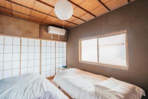 um quarto com 2 camas e uma janela em 松本市の一棟貸し切りできる古民家 em Matsumoto