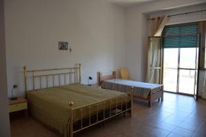 un dormitorio con dos camas y una ventana en FMA Soverato, en Soverato Marina 5 fotos más