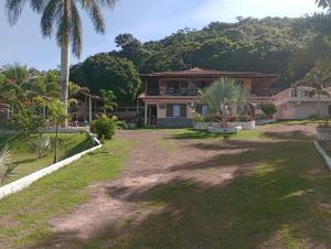 a house with a large yard with palm trees at Pousada Recanto Das Palmeiras in Búzios