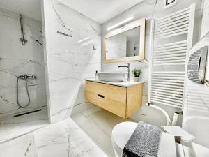 a white bathroom with a sink and a shower at George Airport Apartments in Heraklio Town