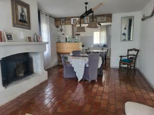 a living room with a fireplace and a table and chairs at Maison de ana in Arles