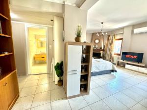 ein Wohnzimmer mit einem Zimmer mit einem Bett und einem Regal in der Unterkunft George Airport Apartments in Iraklio