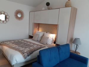ein Schlafzimmer mit einem Bett und einem blauen Stuhl in der Unterkunft CHAMBRE D'HÔTES "Le petit Valadas" à 7km d'UZES in Serviers-et-Labaume