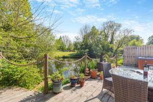 a patio with a table and some potted plants at Tilly's, a two bedroom holiday retreat with hot tub and views of the pond in Barningham