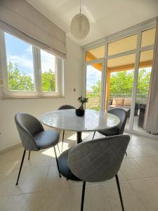 a dining room with a table and chairs and windows at Villa Massilia in Rovinj