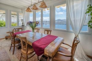 a dining room with a table and some windows at Studios Kilindra in Astypalaia Town