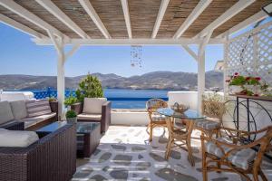 a patio with a table and chairs and a view of the ocean at Studios Kilindra in Astypalaia