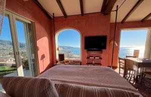 a bedroom with a large bed and a large window at La Casa di Pucci Sanremo in Sanremo