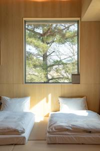 una camera con due letti e una finestra di PBr7 Unusual Stay a Gyeongju