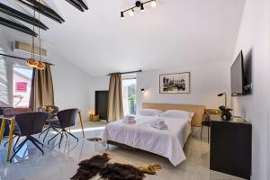 a bedroom with a bed and a table and chairs at VILLA RITA ARTaTORE in Mali Lošinj +59 photos