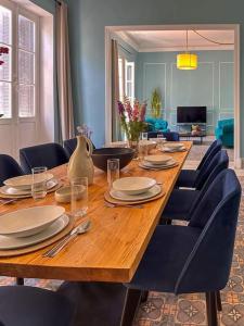 a large wooden table with blue chairs and a dining room at Appartement rénové en plein centre historique in Tunis