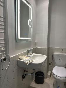 a bathroom with a sink and a toilet and a mirror at Appartement rénové en plein centre historique in Tunis