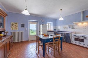 Una cocina con paredes azules y una mesa y sillas azules. en Casale Vergheria, en Magliano in Toscana 23 fotos más