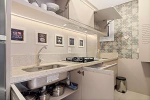 a kitchen with a sink and a stove at Apartamento Loft One 1dorm by Achei Gramado in Gramado +18 photos