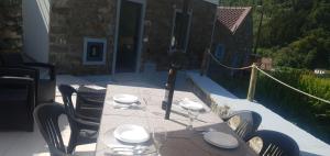 un tavolo con piatti e bicchieri su un patio di Casa do Monte a Faial da Terra