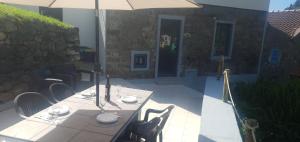 un tavolo con sedie e un ombrellone in un patio di Casa do Monte a Faial da Terra