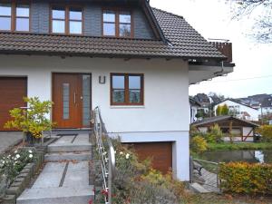 a white house with a brown door at Cosy apartment with private garden in Brachthausen in the Sauerland in Brachthausen