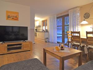 a living room with a large television and a table at Cosy apartment with private garden in Brachthausen in the Sauerland in Brachthausen